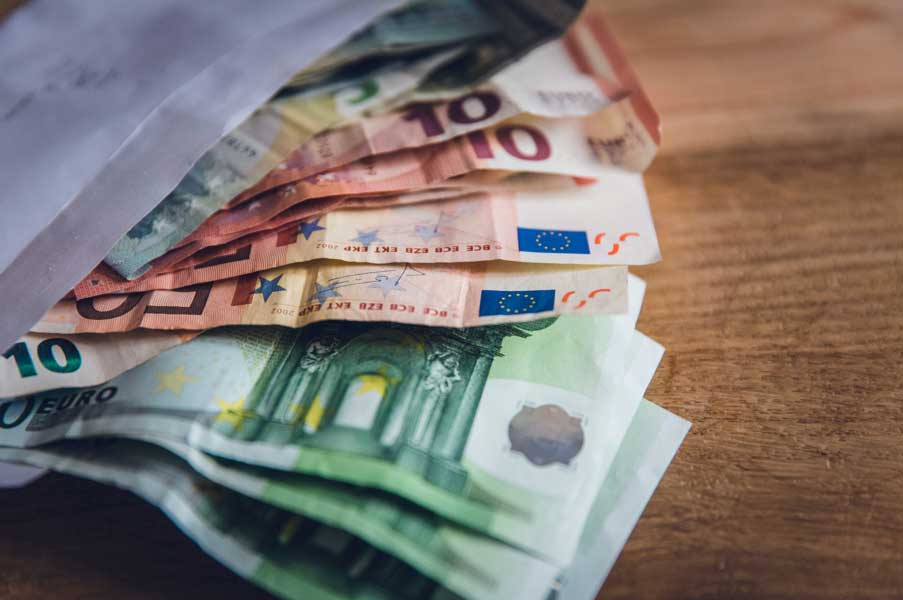 Ein Stapel Euro-Banknoten liegt auf einem Tisch.